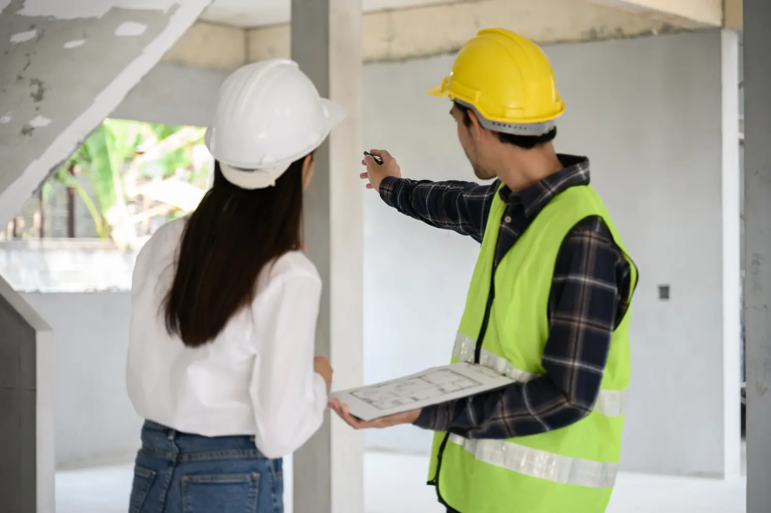 Bauingenieurin mit persönlicher Schutzausrüstung überprüft und berät sich mit dem Vorarbeiter auf der Baustelle, um den Bauprozess während des Folgeprozesses zu inspizieren. Technisches Konzept.